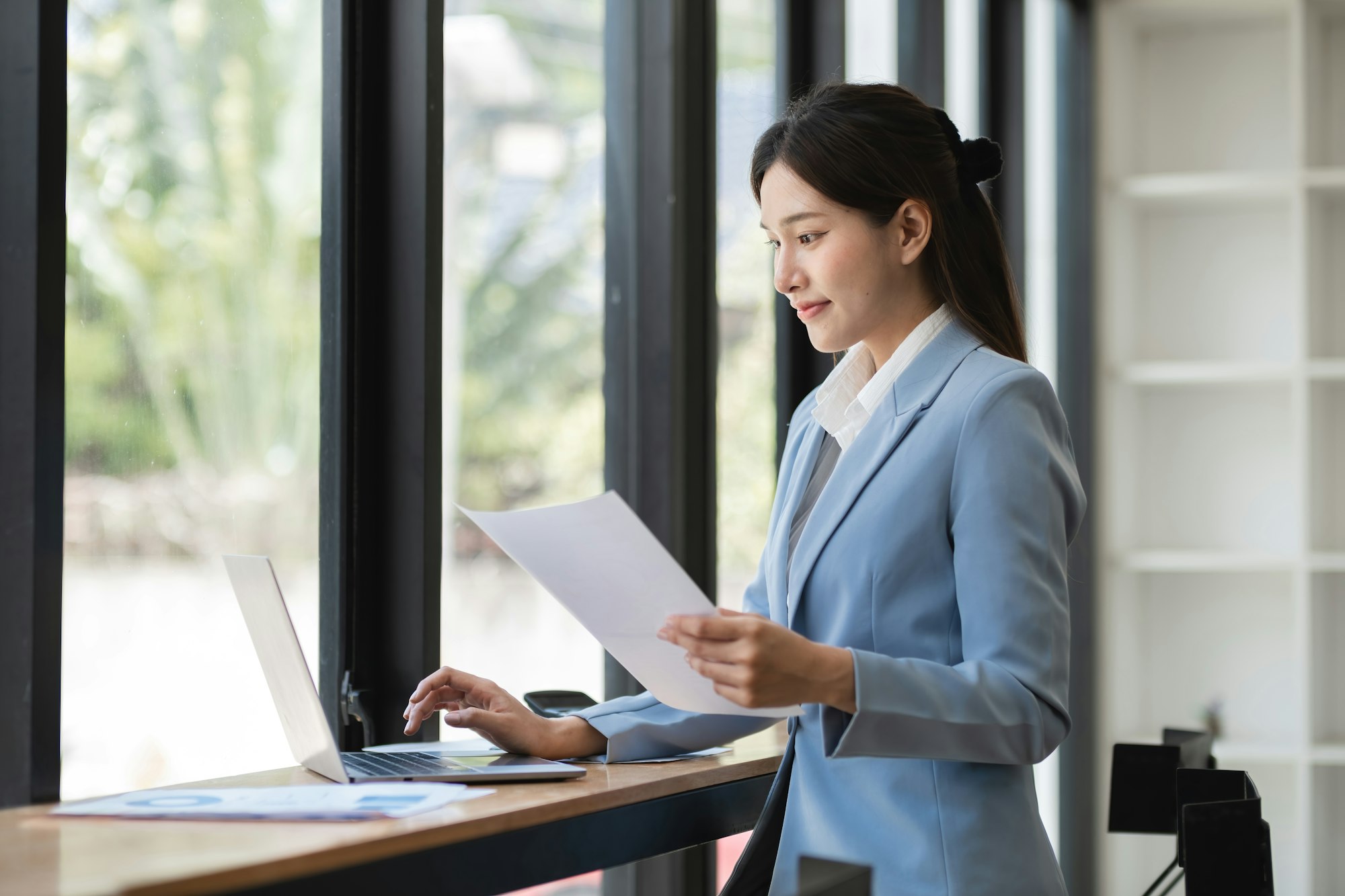 Professional Business Woman Working on Laptop in Modern Office Environment, Analyzing Documents and